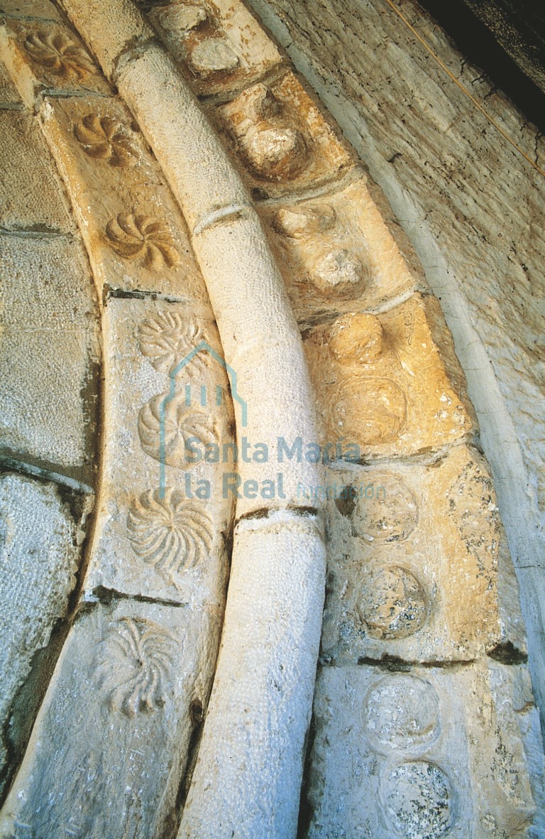 Decoración reutilizada de resetones o símbolos solares de la arquivolta de la portada