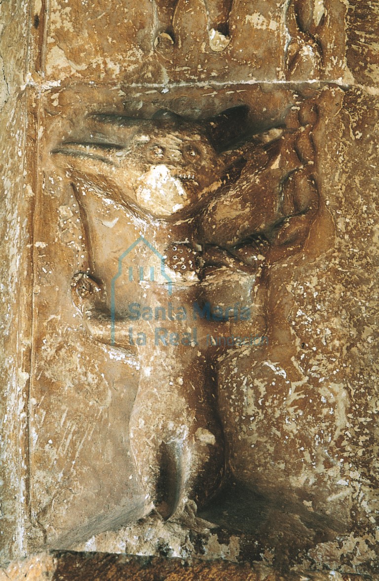 Detalle de la portada, lado occidental representando un demonio encadenado con llave