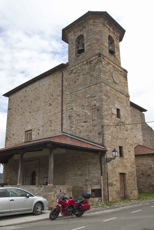 Vista general de la iglesia con la torre y el pórtico en primer termino