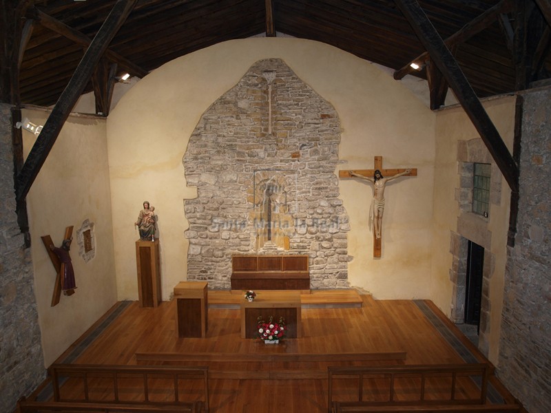 Vista interior desde el coro con los restos al fondo del muro oriental original del edificio del siglo XI