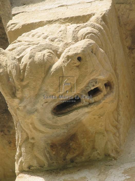 Canecillo de fiero león en actitud desafiante, en el ábside del lado de la epistola