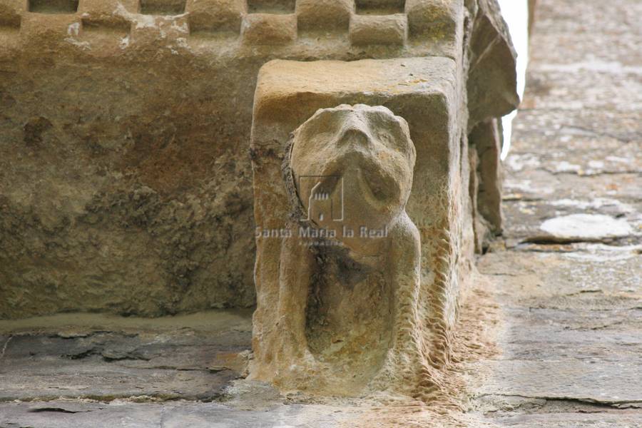Primer canecillo del anteábside por el lado norte. Cabezota de monstruo patilargo