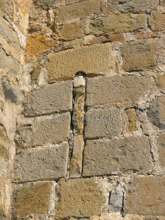 Detalle de una saetera cegada en el ábside