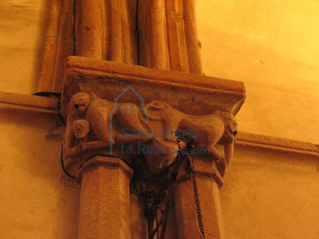 Capiteles de las columnas pareadas del presbiterio. Cabeza humana y dos parejas de monos con una única cabeza que sostienen entre sus garras otras figurillas humanas