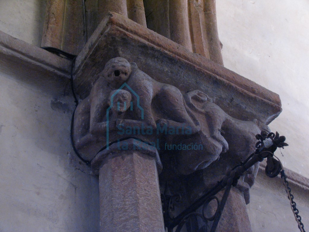 Capiteles de las columnas pareadas del presbiterio. Cabeza humana y dos parejas de monos con una única cabeza que sostienen entre sus garras otras figurillas humanas
