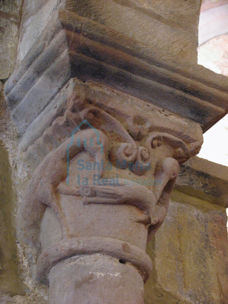 Capitel izquierdo del arco triunfal decorado con dos aves picoteando un bicho