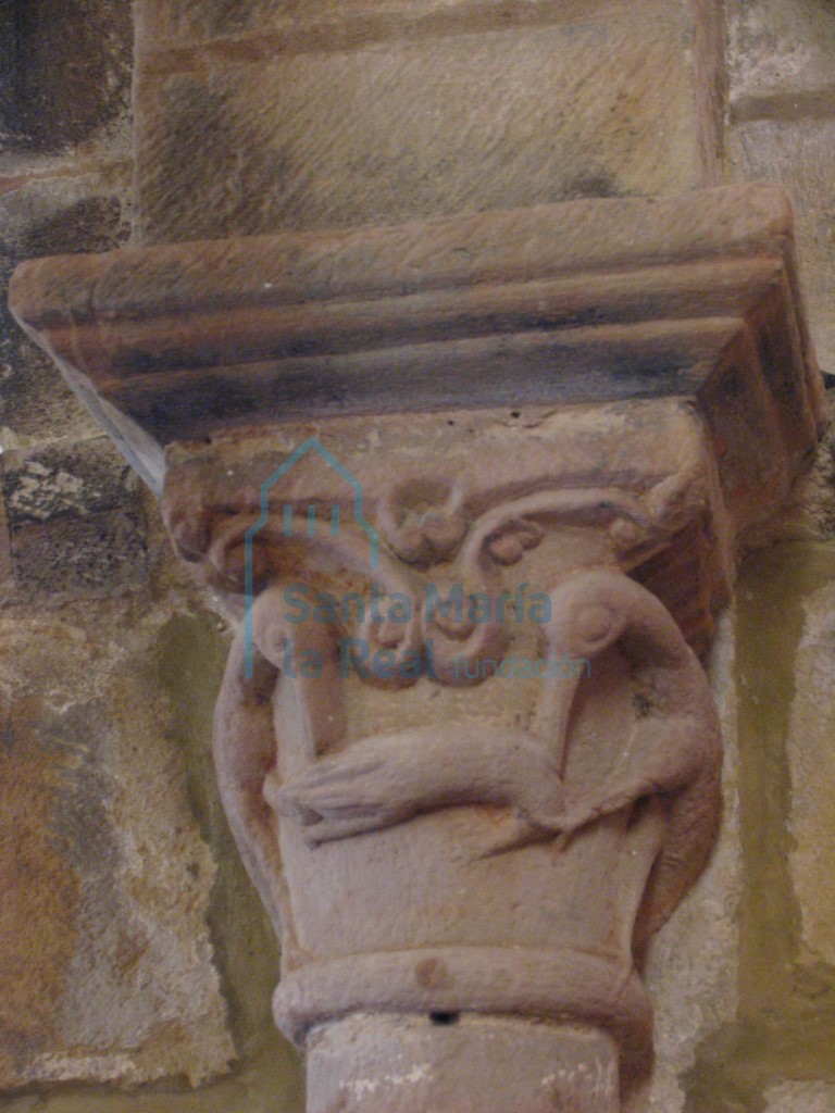 Capitel izquierdo del arco triunfal decorado con dos aves picoteando un bicho