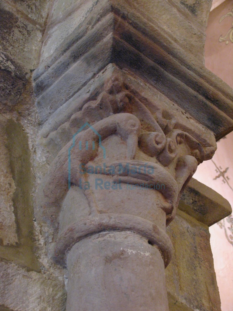 Capitel izquierdo del arco triunfal decorado con dos aves picoteando un bicho