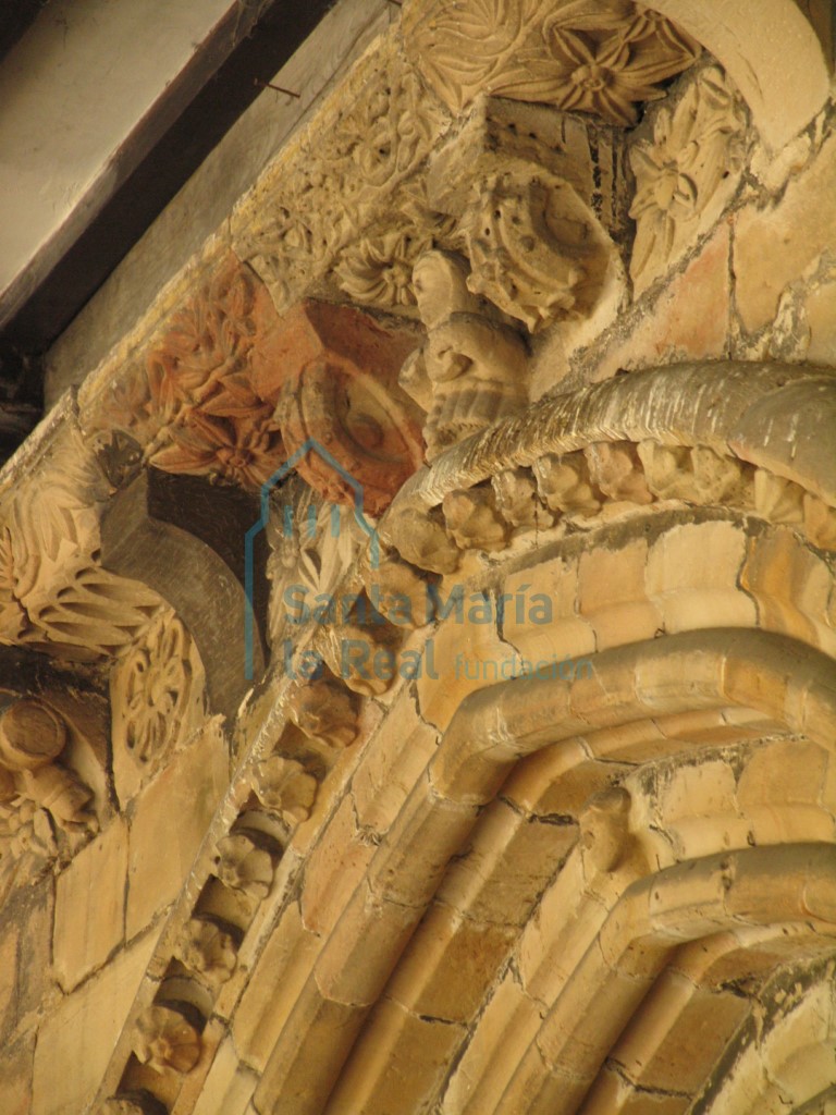 Clave del arco de la portada occidental y canecillos