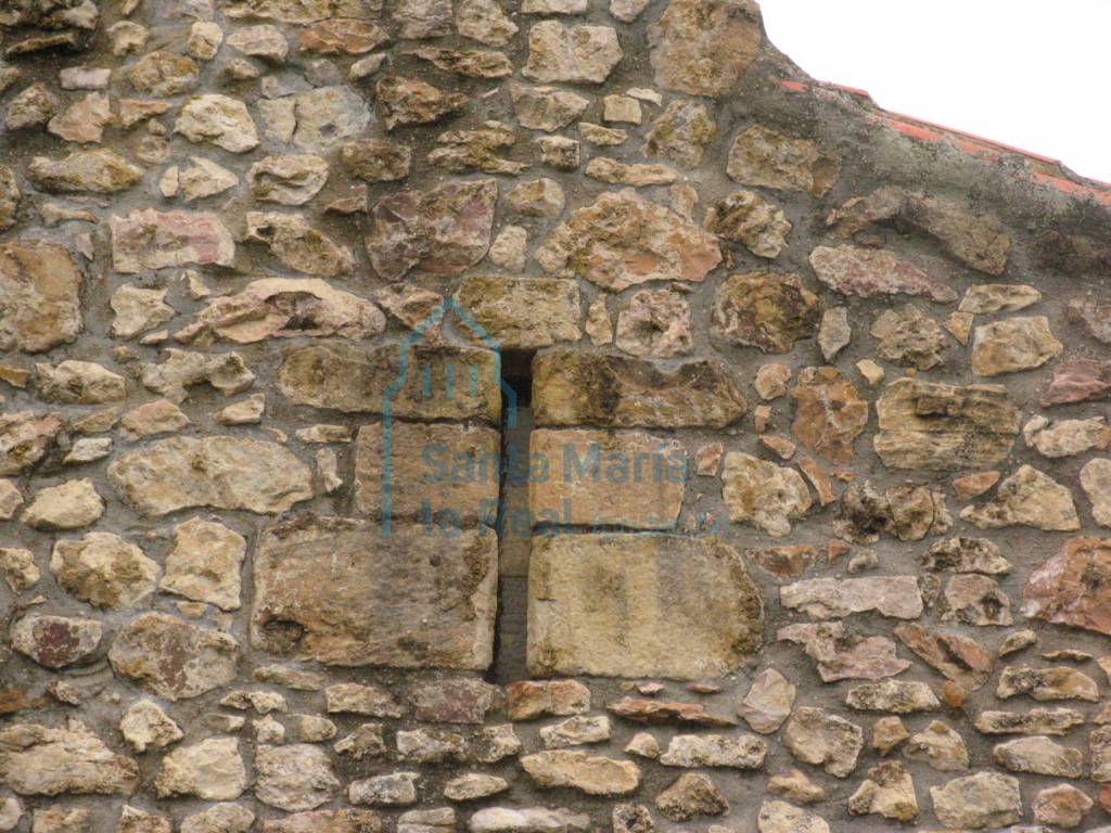 Detalle de una aspillera reutilizada en el imafronte