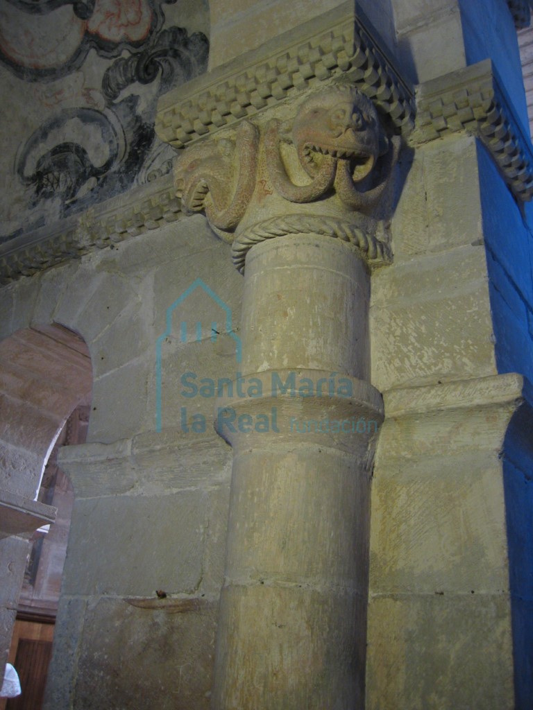 Capitel de la arquería absidal. Dos cabezas monstruosas de cuyas bocas salen dos sierpes