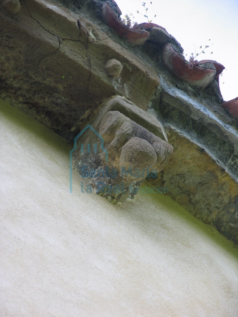 Canecillo del ábside. Personaje portando una barrica