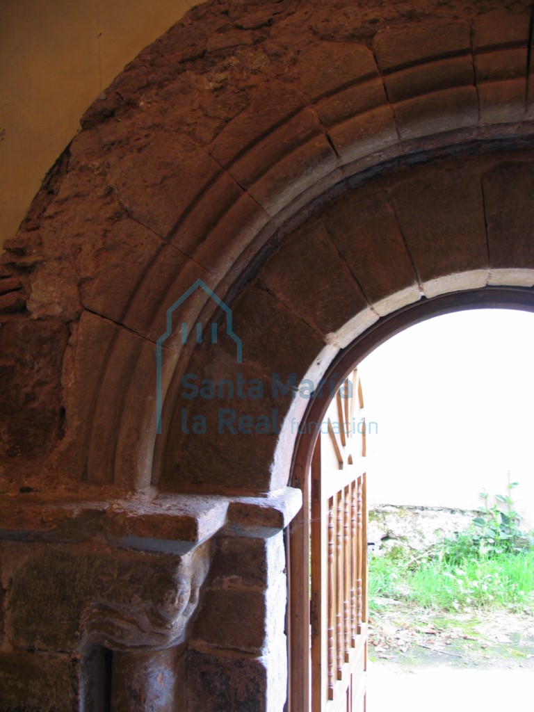 Detalle del lado izquierdo de la portada románica en el muro norte de la nave