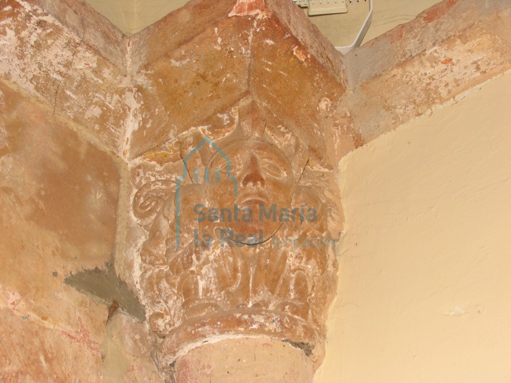 Capitel interior del arco triunfal en el lado del evangelio. Hombrecillos ocultos tras una máscara humana