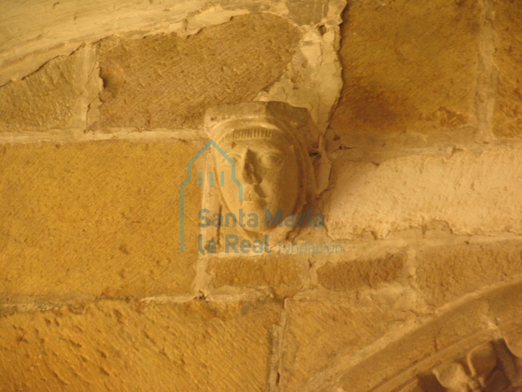 Canecillo o ménsula representando una cabeza masculina sobre la portada que comunica el claustro con el zaguán