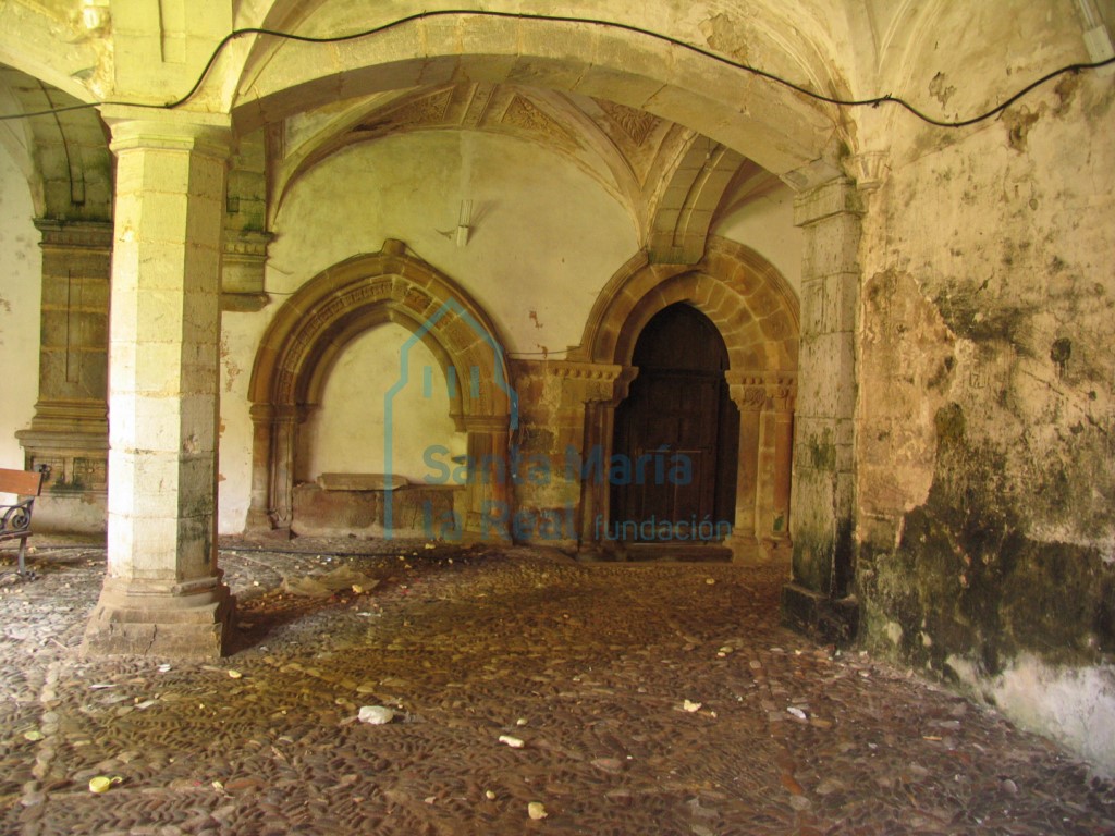 Vista del arcosolio gótico y la portada que comunica el claustro con el zaguán