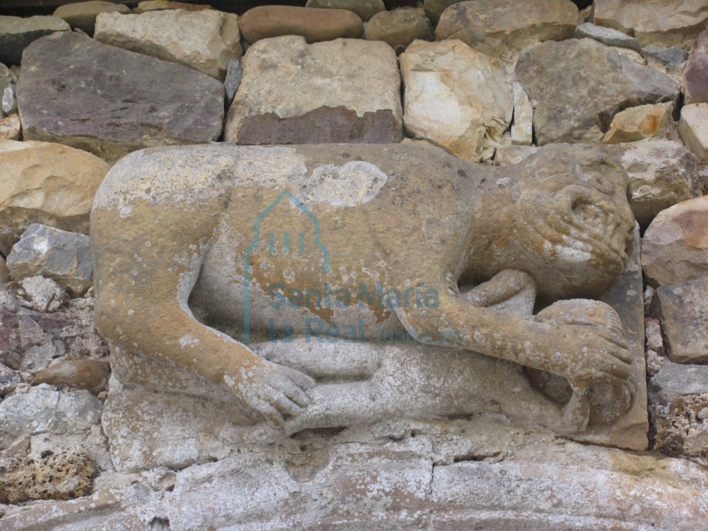 Detalle de la primitiva portada de acceso a las huertas del monasterio. Bestia con una figura humana entre las garras
