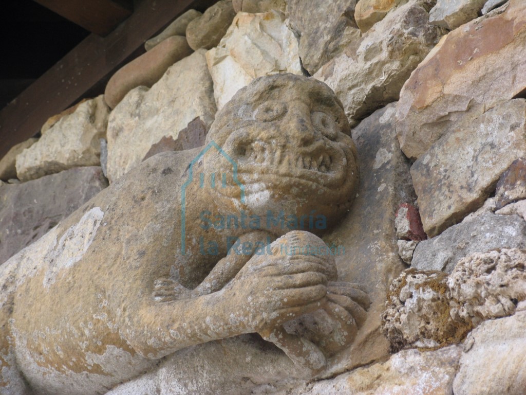 Detalle de la primitiva portada de acceso a las huertas del monasterio. Bestia con una figura humana entre las garras