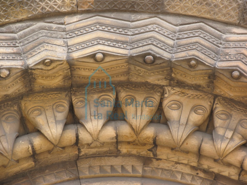 Arquivoltas de la portada occidental. Detalle cabezas de ave mordiendo un grueso bocel