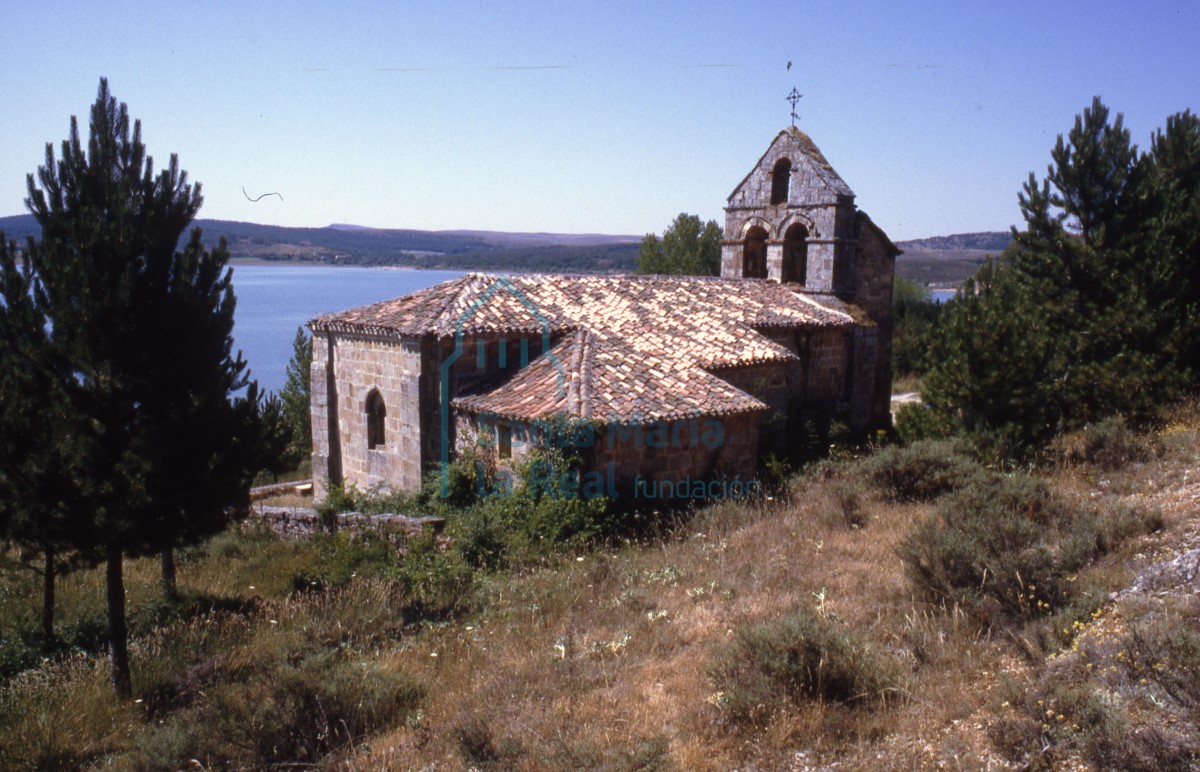 Vista general de la iglesia con el pantano de Aguilar al fondo.