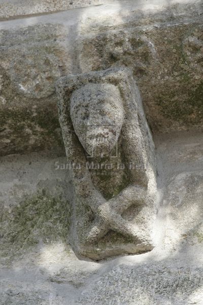 Canecillo de hombre sentado con las piernas cruzadas del muro sur