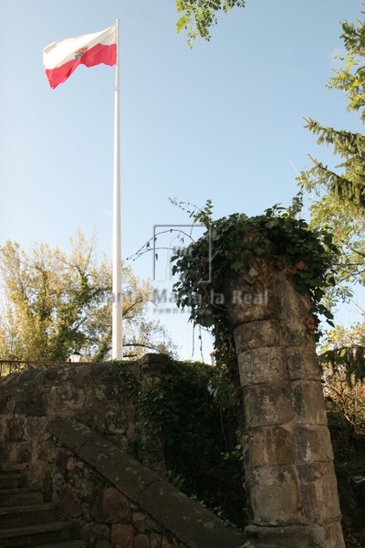 Columna del viejo ábside colocada en la pared de la escalera con la bandera de la comunidad de Cantabria al fondo