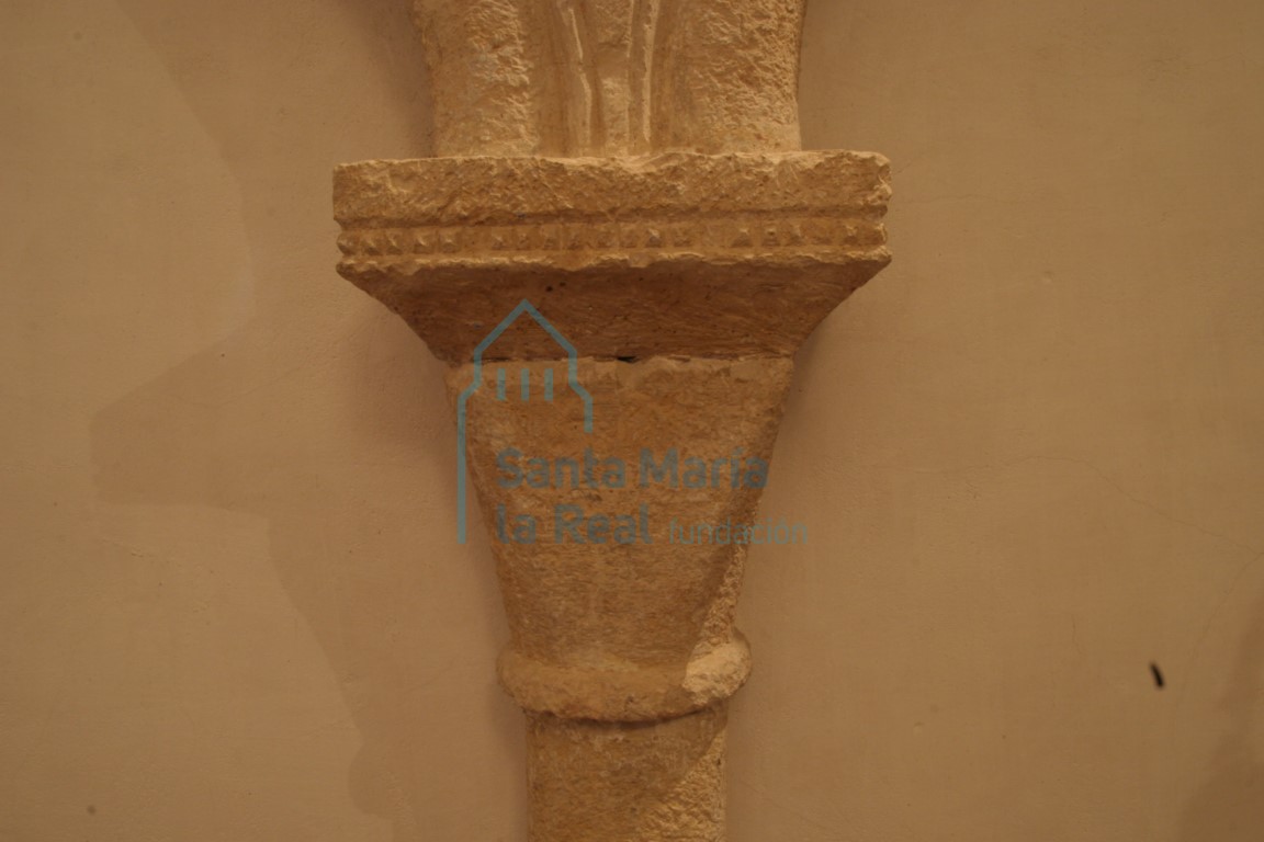 Detalle del capitel de la arquería ciega del presbiterio con cimacio sencillo decorado con una hilera de pequeñas puntas de clavo