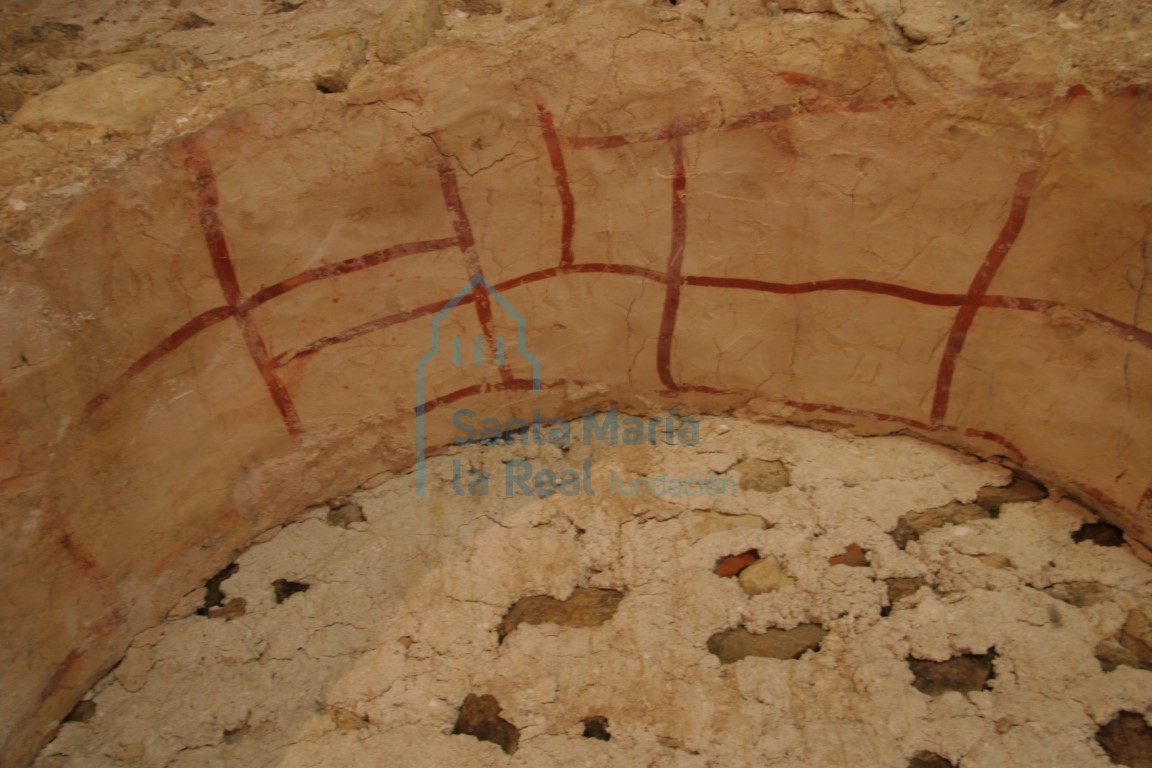 Detalle de pintura rojiza en uno de los arcos del antiguo pórtico simulando despiece de sillar