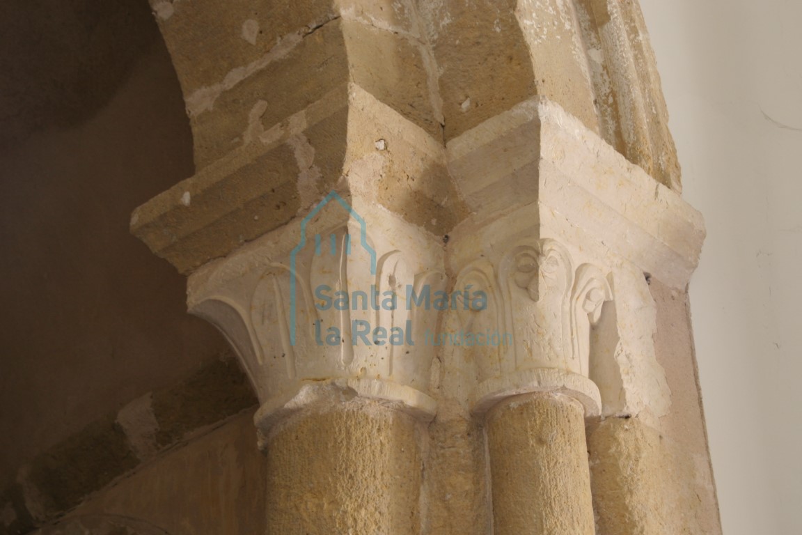Capiteles con decoración vegetal, uno de hojas puntiagudas partidas por un acusado nervio central mientras que en la otra cesta las hojas se curvan en la punta formando pequeños cogollos. Ubicados en el acceso al ábside más meridional