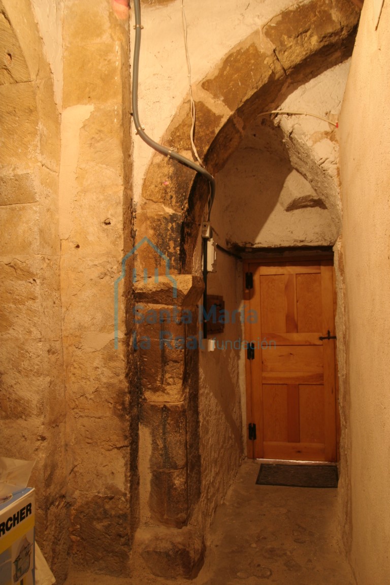 Arco de medio punto sobre jambas primáticas con las esquinas matadas por un bocel, con cimacio en forma de chaflán semicegado, por el que se accede a la iglesia