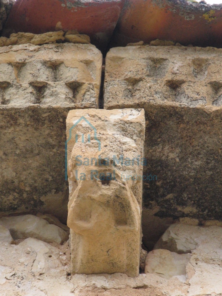 Canecillo del ábside,personaje en actitud de burla