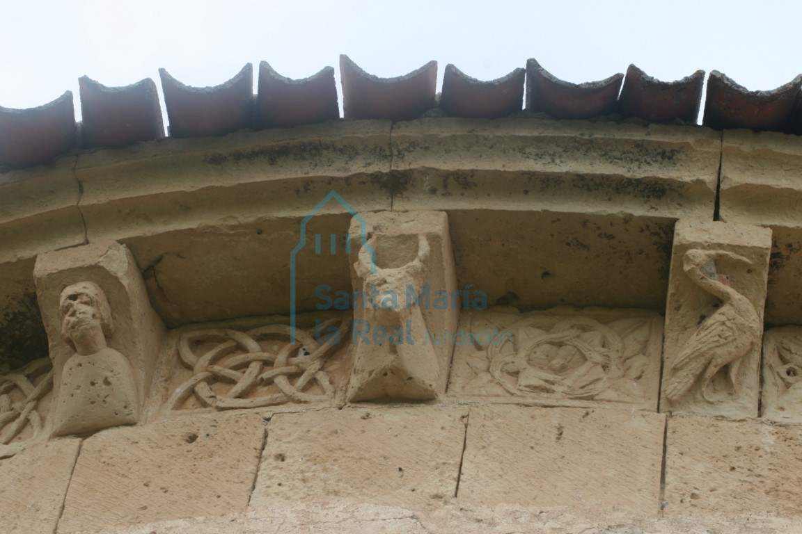 Canecillos de figuras humanas y de animales, y metopas decoradas con rosetas y motivo de entrelazo, en el ábside
