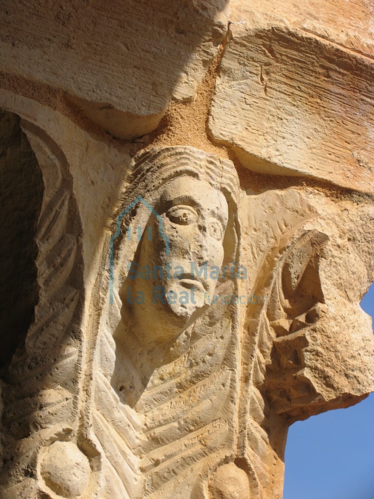 Capitel del pórtico. Hojas de acanto entre las que se intercalan cabezas humanas