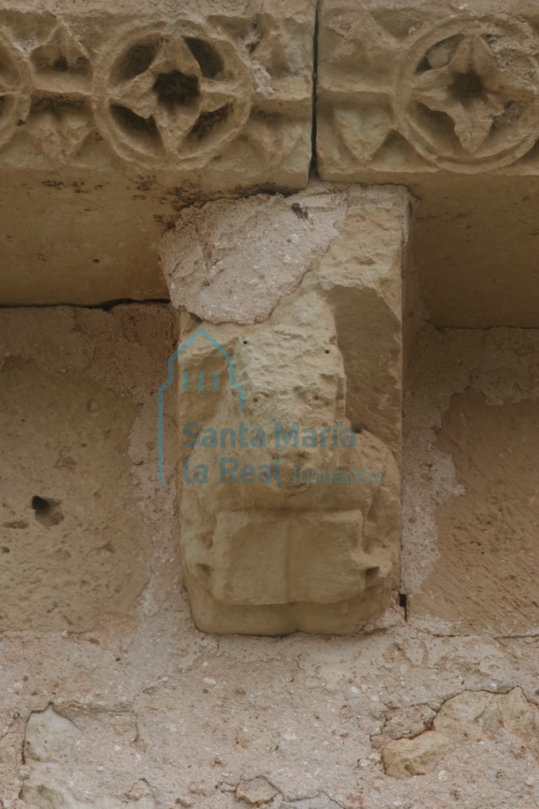 Canecillo con una figura mostrando un libro