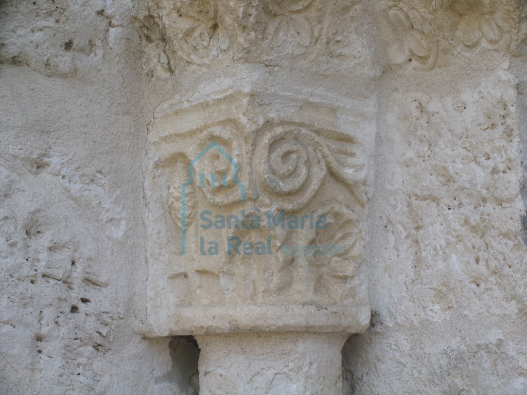 Capitel de la portada muestra motivos vegetales, entre los que se pueden distinguir una piña, una roseta, dos tallos en espiral y una esquemática hoja de acanto.