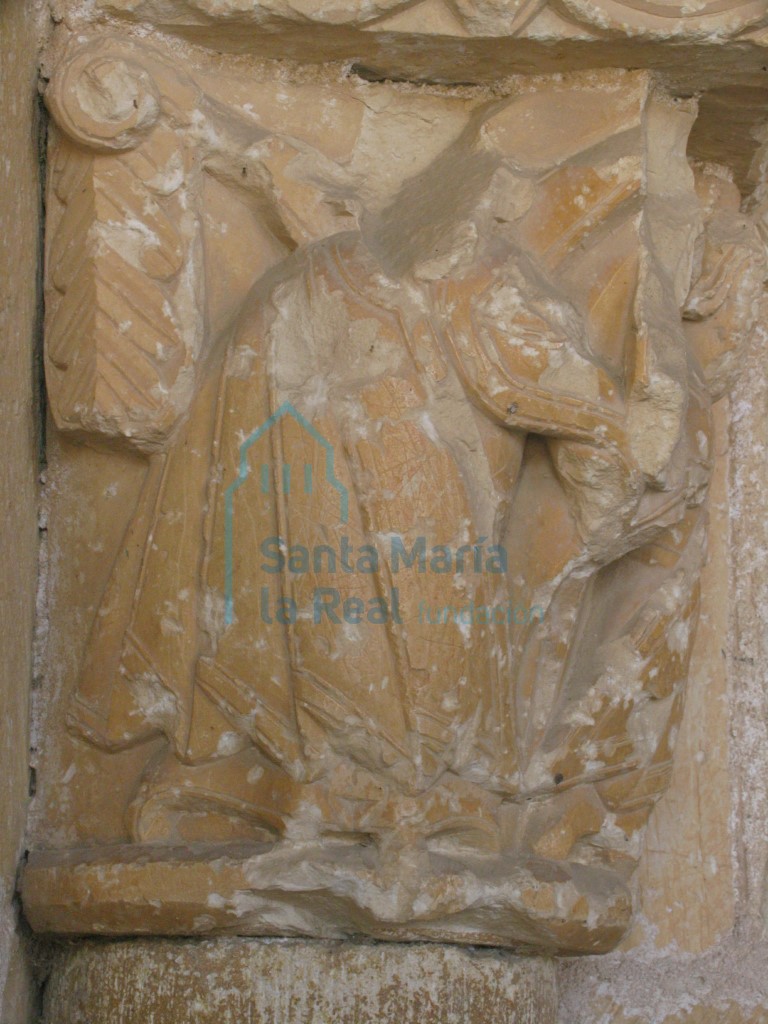 Detalle del capitel izquierdo de la portada, que representa un hombre con una larga túnica