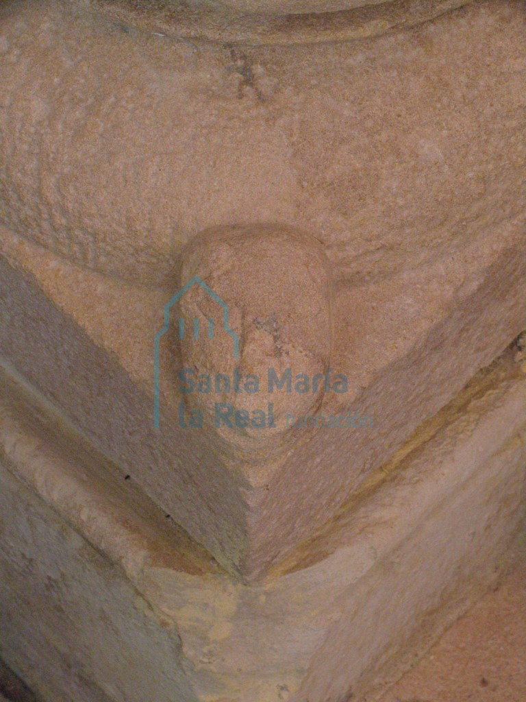 Detalle de una cabeza en la basa de la columna del arco triunfal