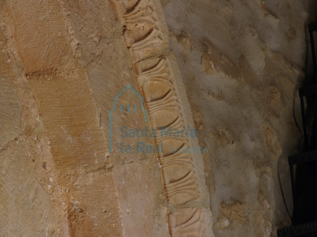 Detalle de la chambrana de la portada meridional decorada con ramilletes que moldean senciallas hojas lanceoladas