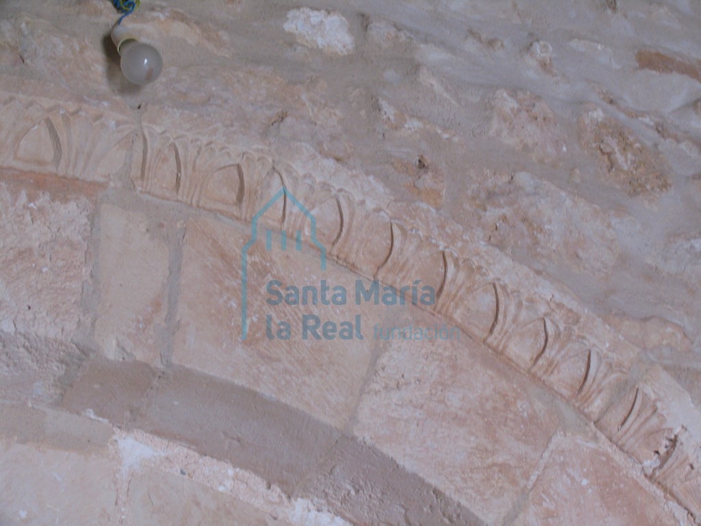 Detalle de la chambrana de la portada meridional con decoración de ramilletes moldeados que perfilan hojas lanceoladas Detalle de la chambrana de la portada meridional con decoración de ramilletes moldeados que perfilan hojas lanceoladas