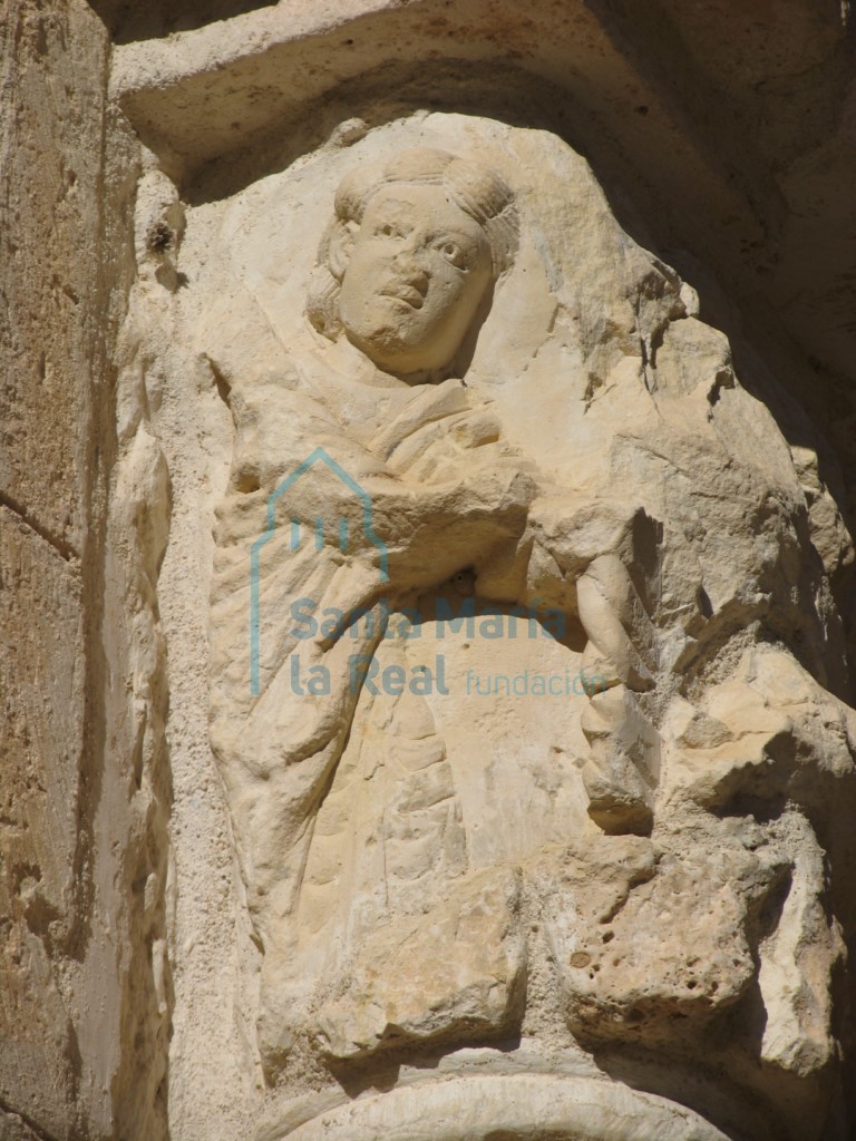 Capitel del pórtico. Figura humana vestida con un manto