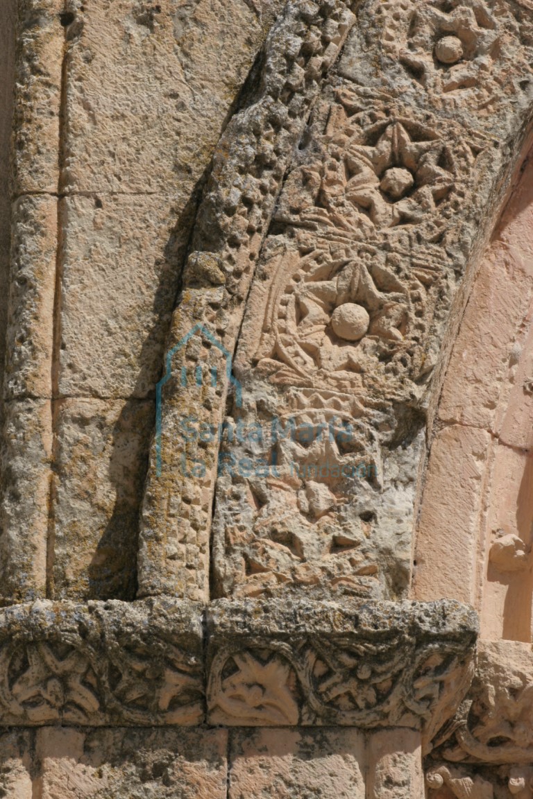 Detalle de la decoración de espinosas rosetas inscritas en clípeos perlados en la arquivolta externa, y de la chambrana decorada con billetes