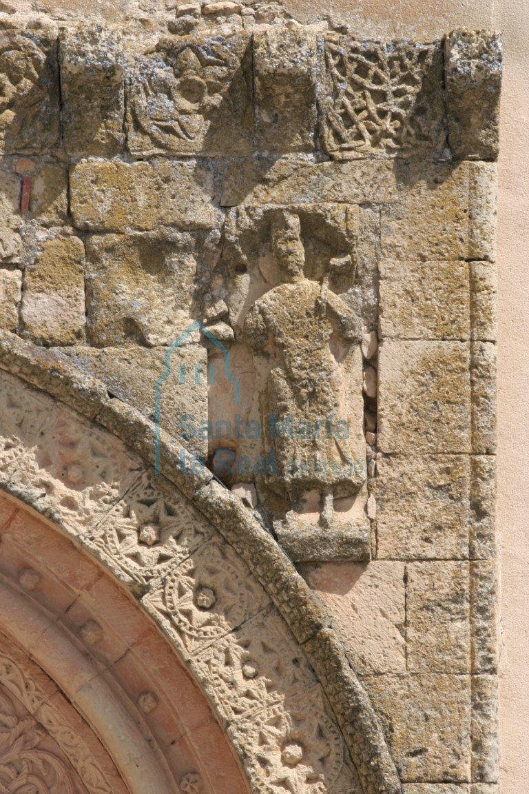 Detalle de la enjuta derecha, relieve de un eclésiastico vestido con ropas talares y sosteniendo un libro en su extendida diestra