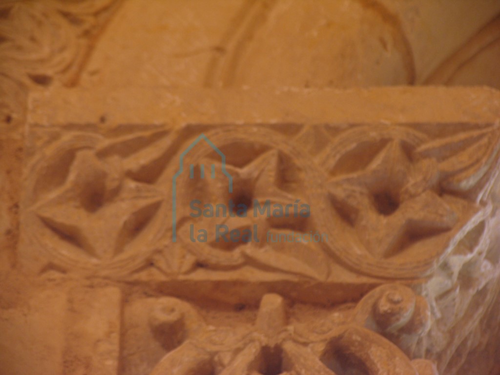 Cimacio con flores de cuatro pétalos en roleos, en la ventana del ábside en la parte interior