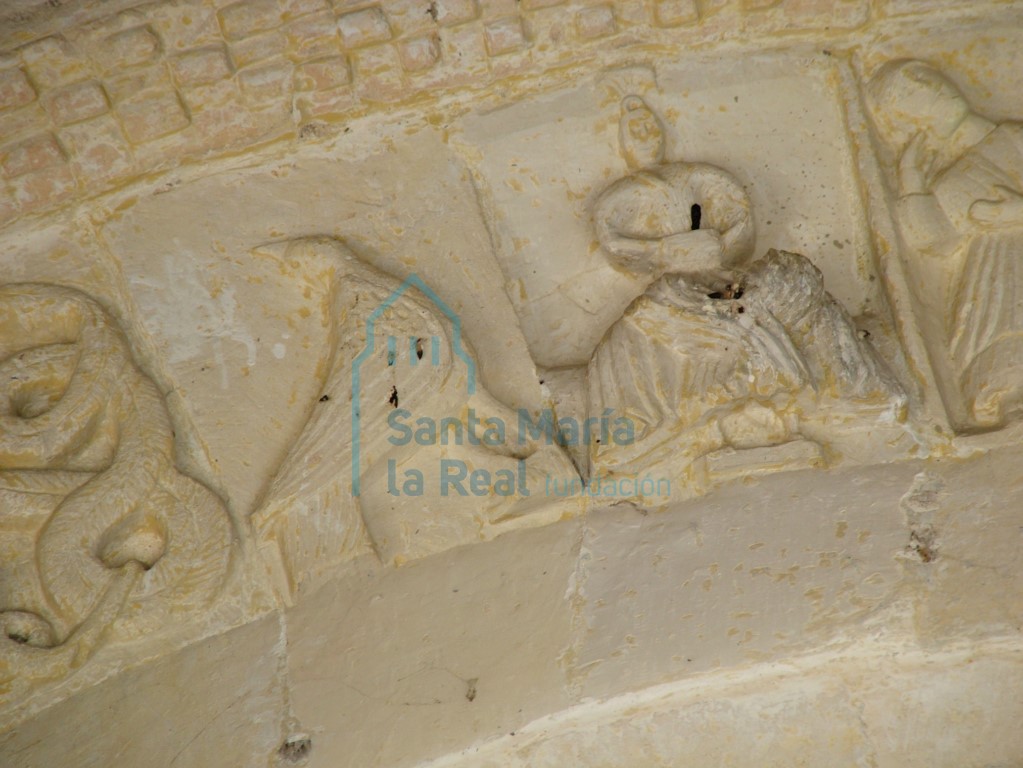 Representación de un ave y una figura humana en arquivolta exterior de la portada meridional