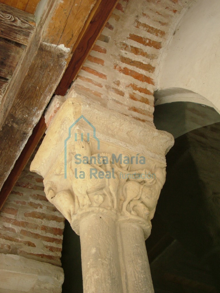 Tercer capitel del pórtico, en este lateral con dos leones armados por la cabezas por una figura humana