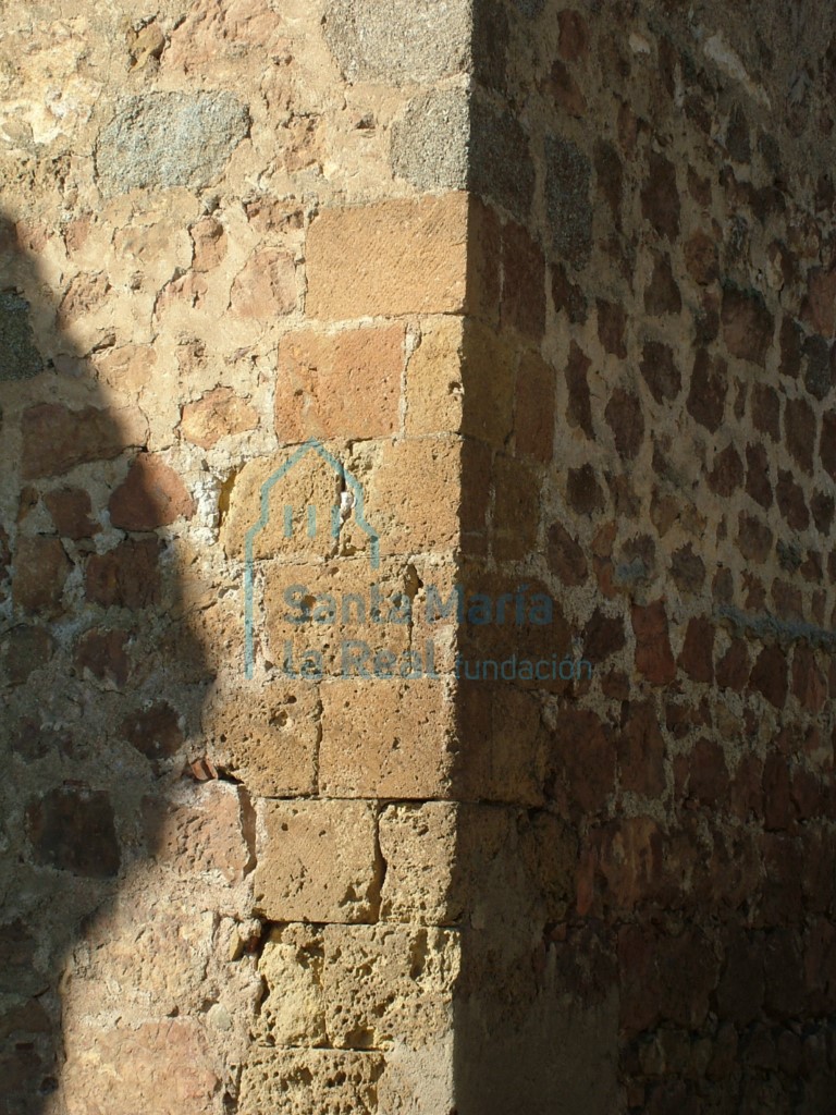 Sillares del edificio románico primitivo reutilizados y conservados en la esquina exterior más occidental de la base de la torre