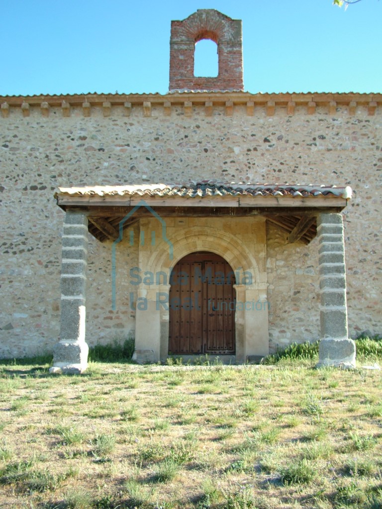 Entrada cubierta por un tejadillo a tres aguas