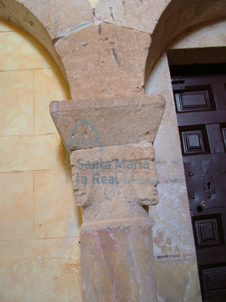Vista de las cabecillas masculina en el capitel del arco del presbiterio del lado del evangelio