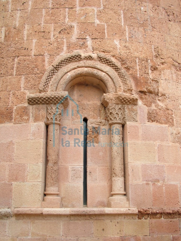 Vano de la zona central del ábside, formado por una arco de medio punto con guardapolvos sobre columnillas, la decoración de los capiteles es de amplía reticula