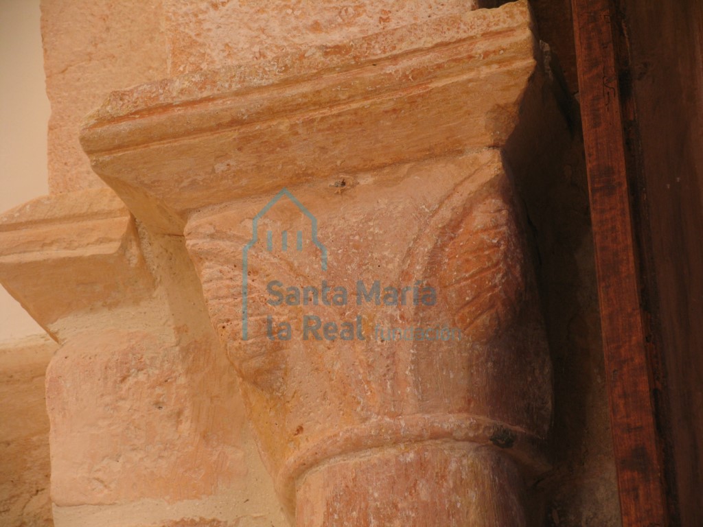 Capitel derecho con dos hojas que acogen unas piñas, del arco triunfal